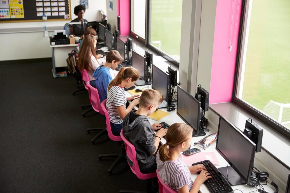 lycéens travaillant sur des écrans dans une classe d'informatique 
