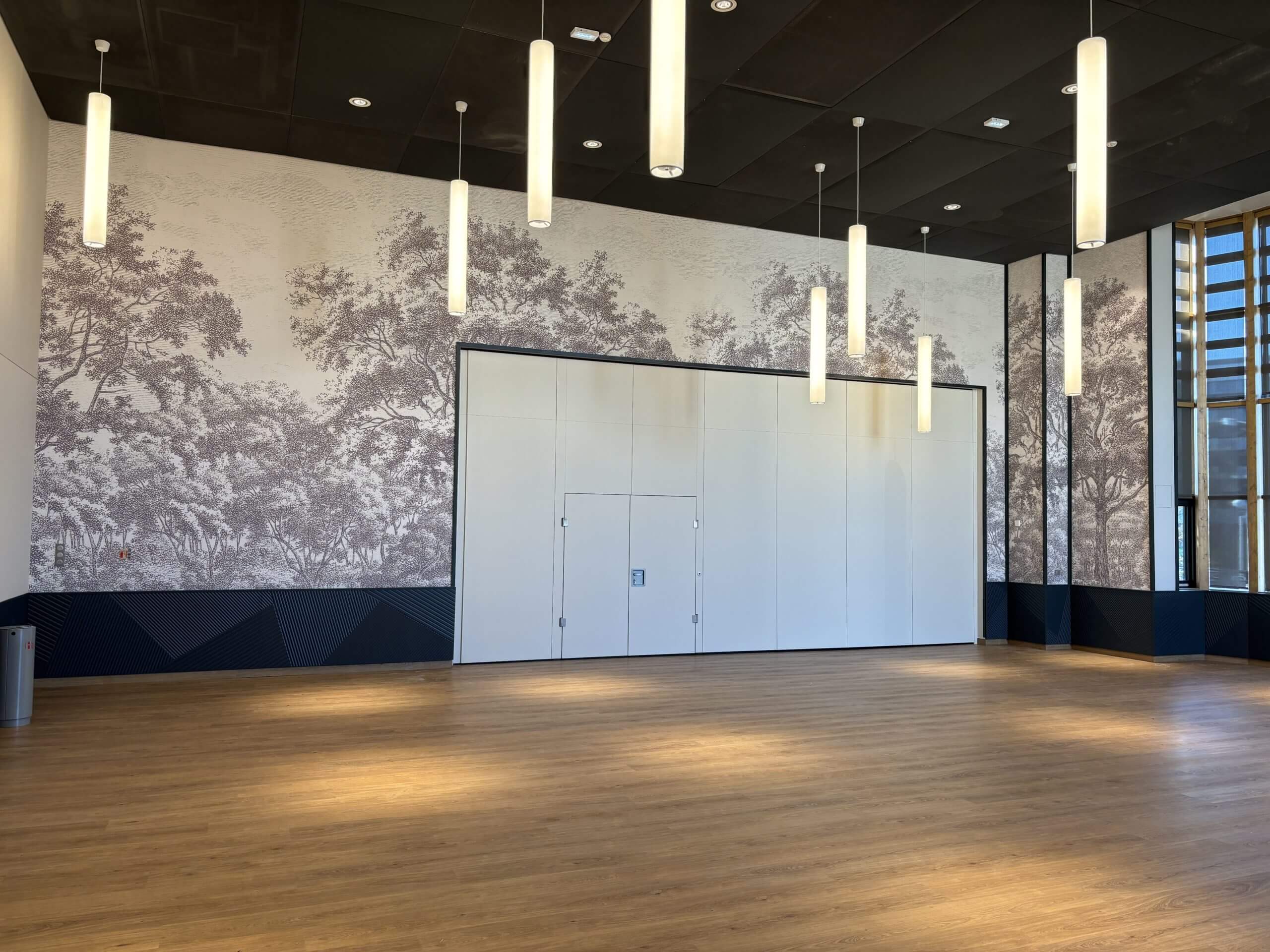 Cloison mobile blanche avec double porte dans une grande salle polyvalente